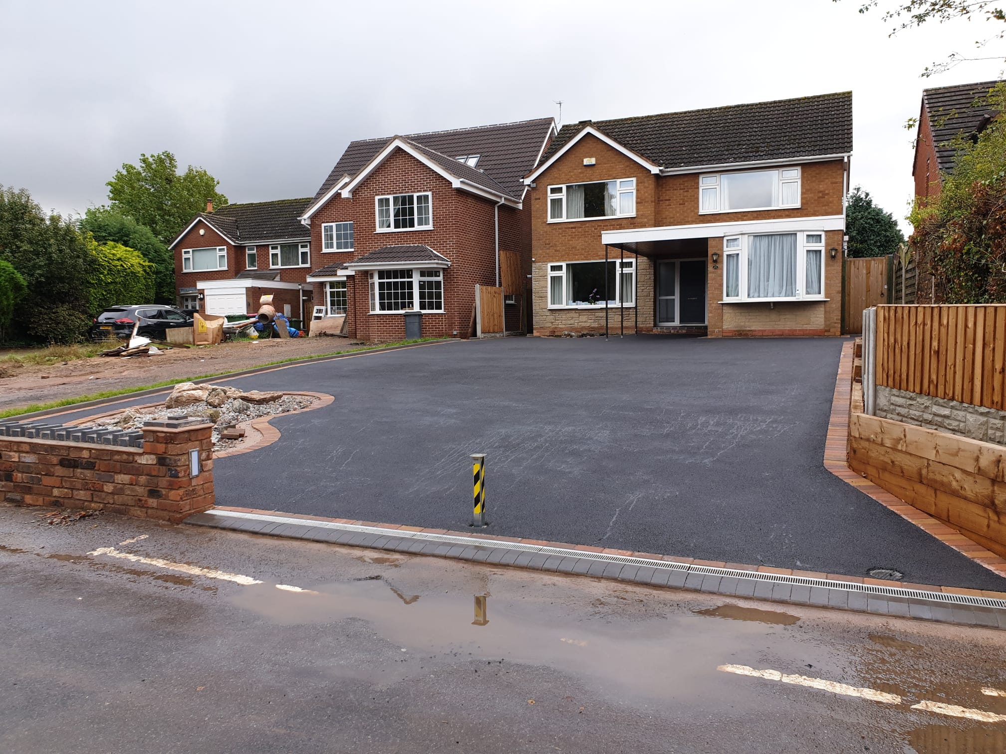 Wide finished tarmac driveway with block paved entrance edging