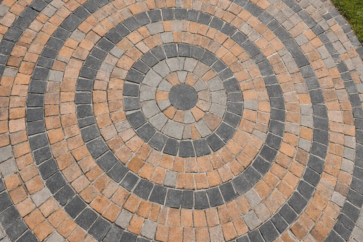Circular block paving feature formed with contrasting charcoal and brindle blocks